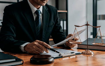 Legal professsional at LKS reviews documents with scales of justice, illustrating firm’s values.